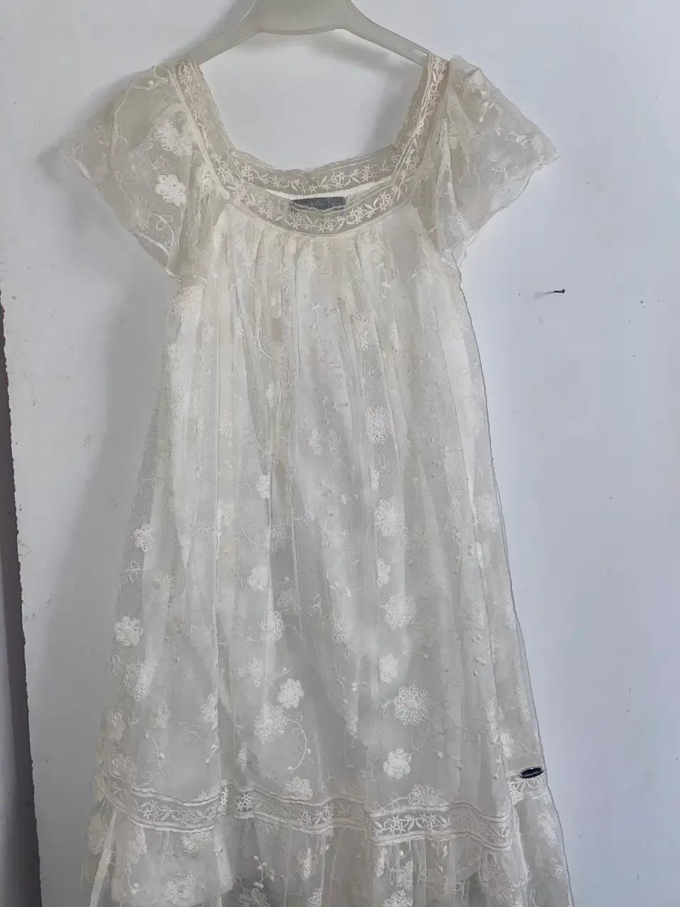 Vestido mini de encaje blanco, ideal para un look romántico y delicado. Perfecto para eventos especiales o para darle un toque especial a tu día a día. Talle 10. 