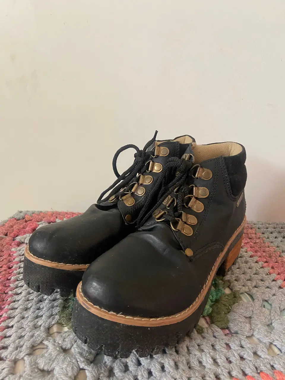 Borcegos negros de cuero con suela gruesa y detalles dorados. Ideales para un look urbano y moderno.
