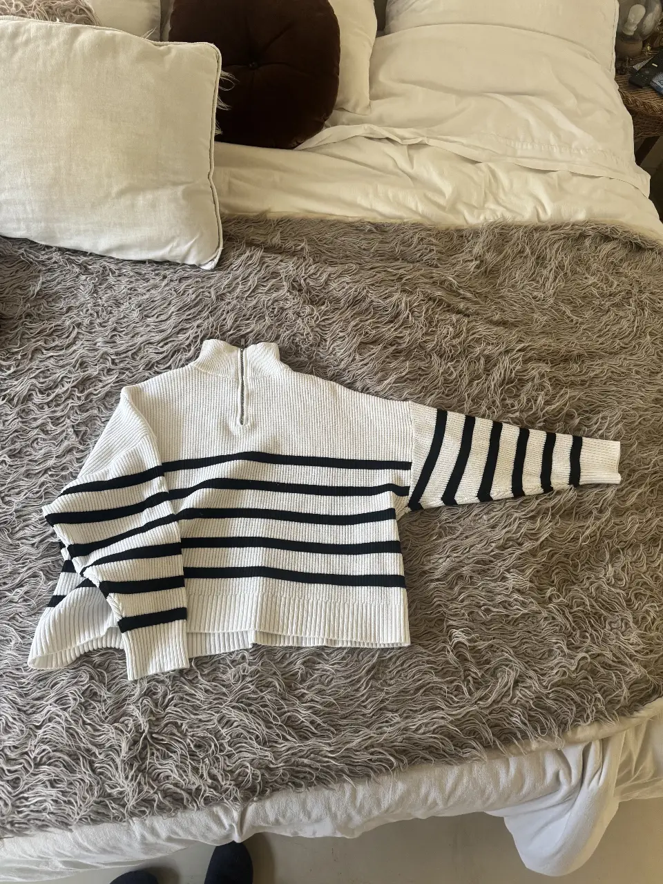 Sweater de cuello alto con cierre y rayas horizontales en blanco y negro. Ideal para un look casual y abrigado.