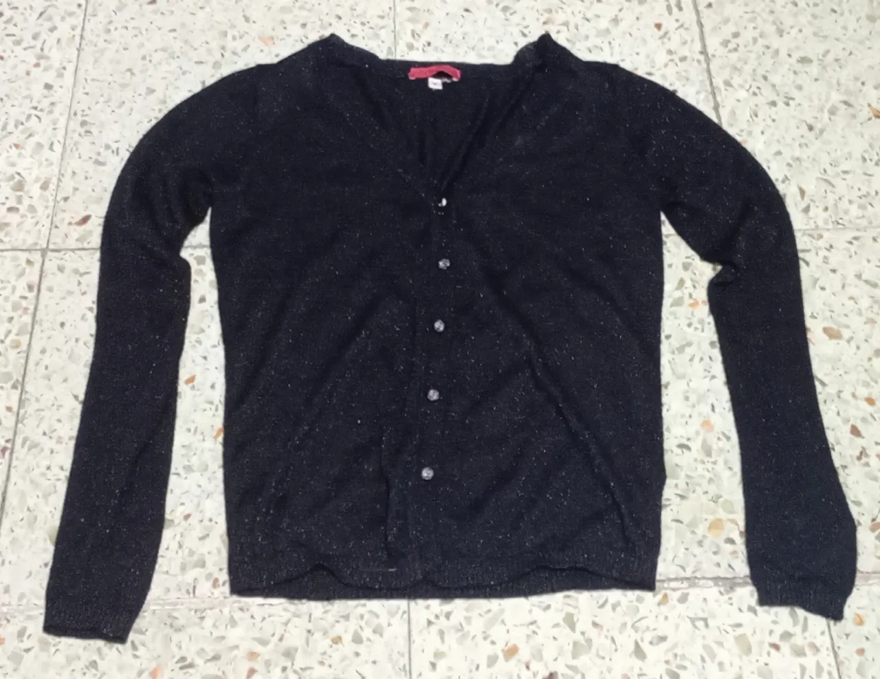 Cardigan negro con brillos, ideal para un look elegante o casual. Posee botones al frente y mangas largas.