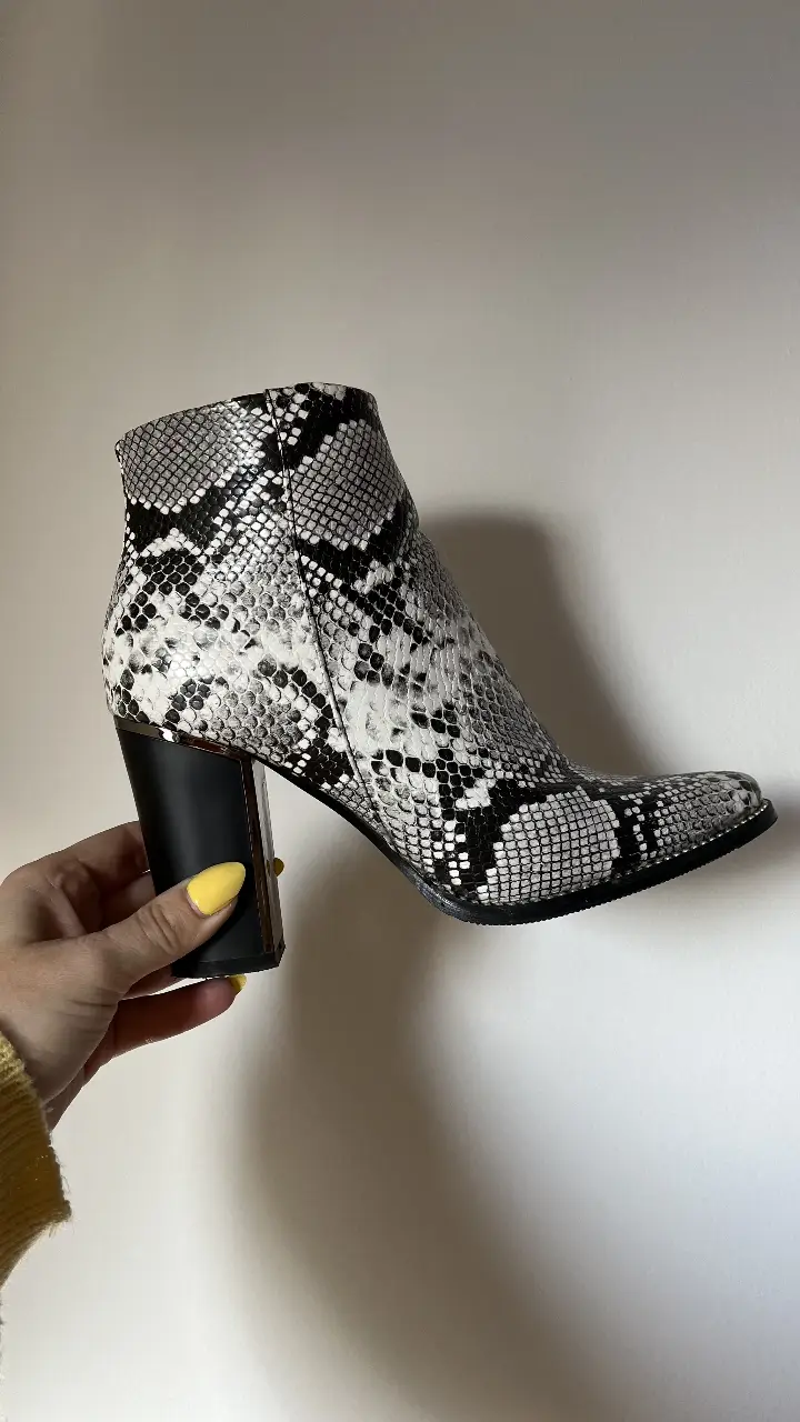 Botines de mujer con estampado de serpiente en blanco y negro. Tienen taco ancho negro y cierre lateral. Ideales para darle un toque moderno a cualquier look.