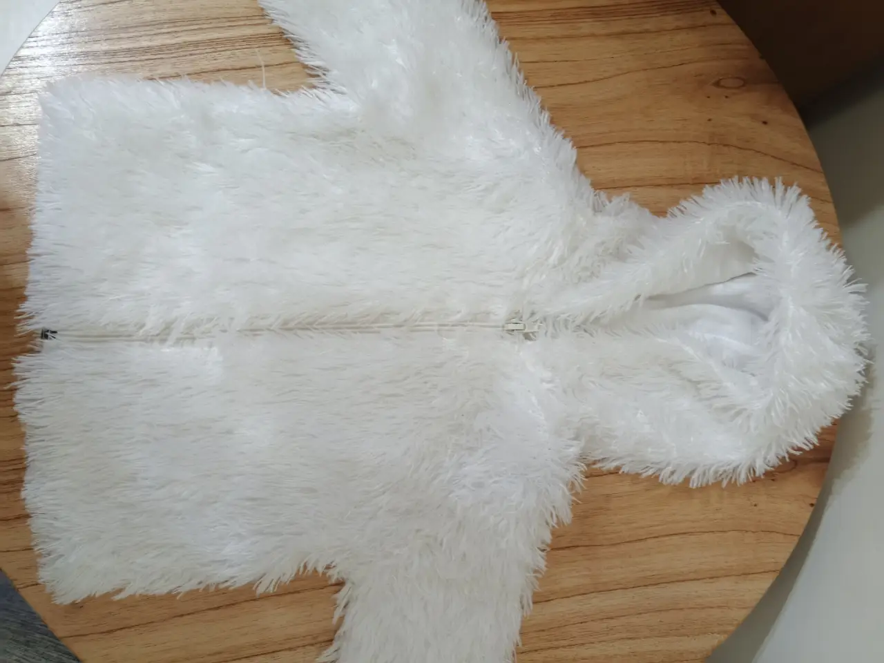 Campera de abrigo para niño/a, de peluche blanco con capucha y cierre frontal. Ideal para mantener a los más pequeños abrigados y cómodos.