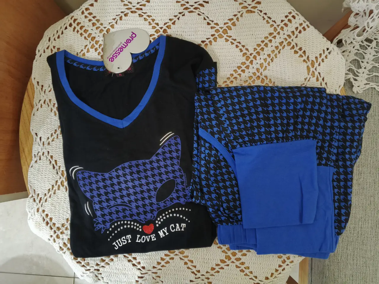 Pijama de dos piezas para mujer, con remera negra con estampado de gato y pantalón con estampado de pata de gallo en azul y negro. Ideal para estar cómoda en casa.