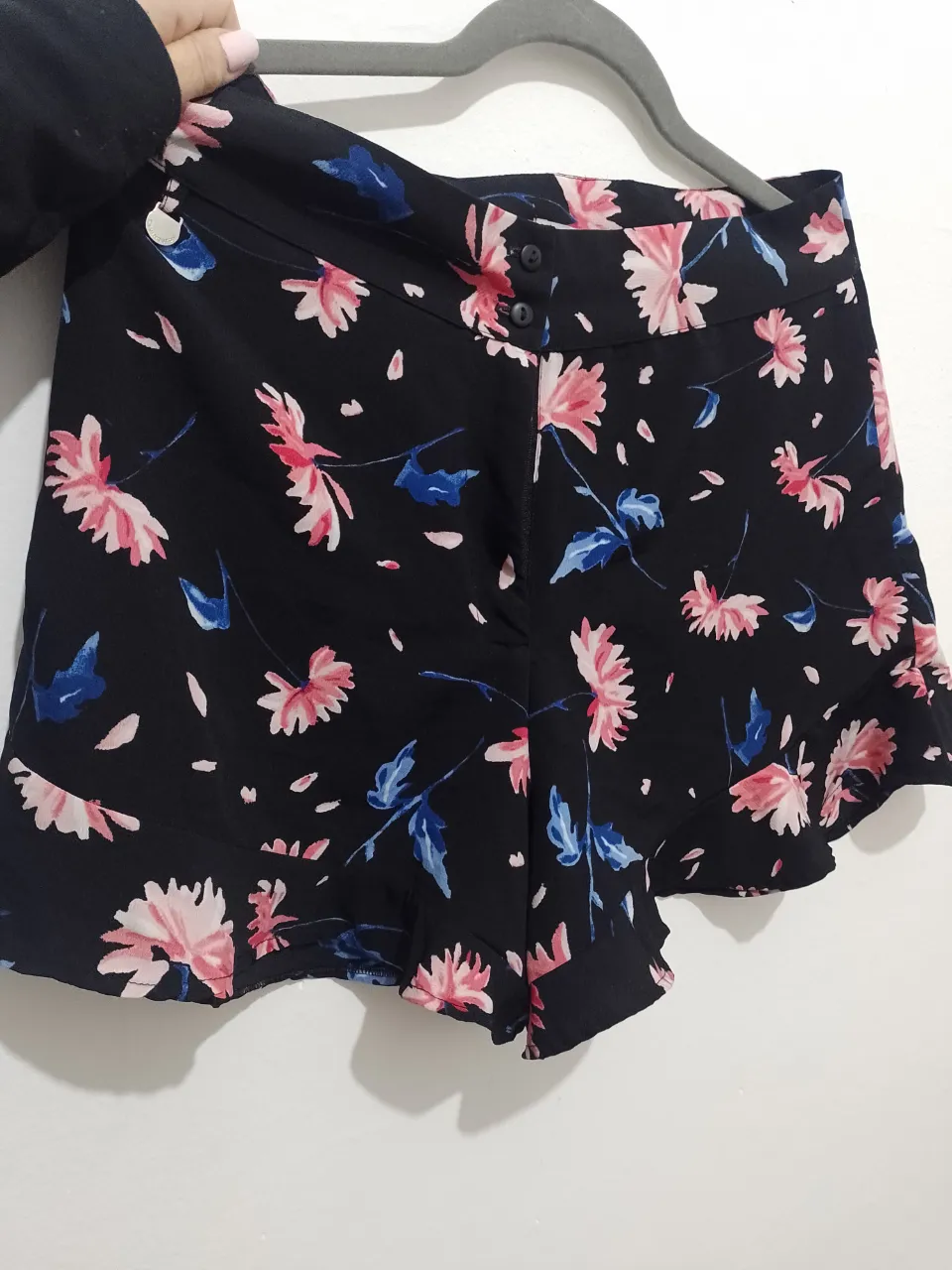 Short de tela negra con estampado floral en tonos rosa y detalles en azul. Ideal para un look fresco y femenino. Excelente estado!