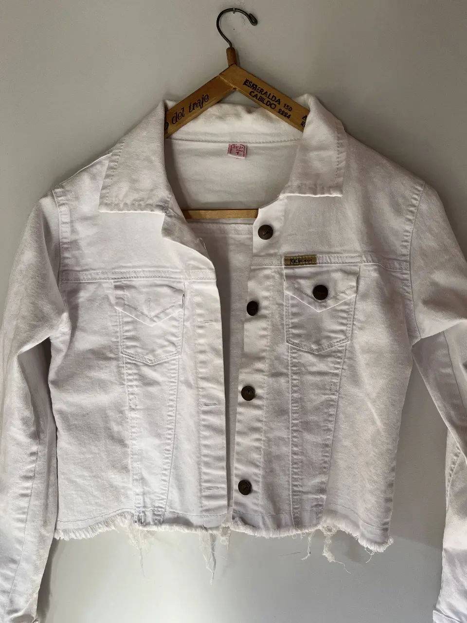 Campera de jean blanca cropped, con detalles desflecados en el bajo. Ideal para un look casual y moderno.