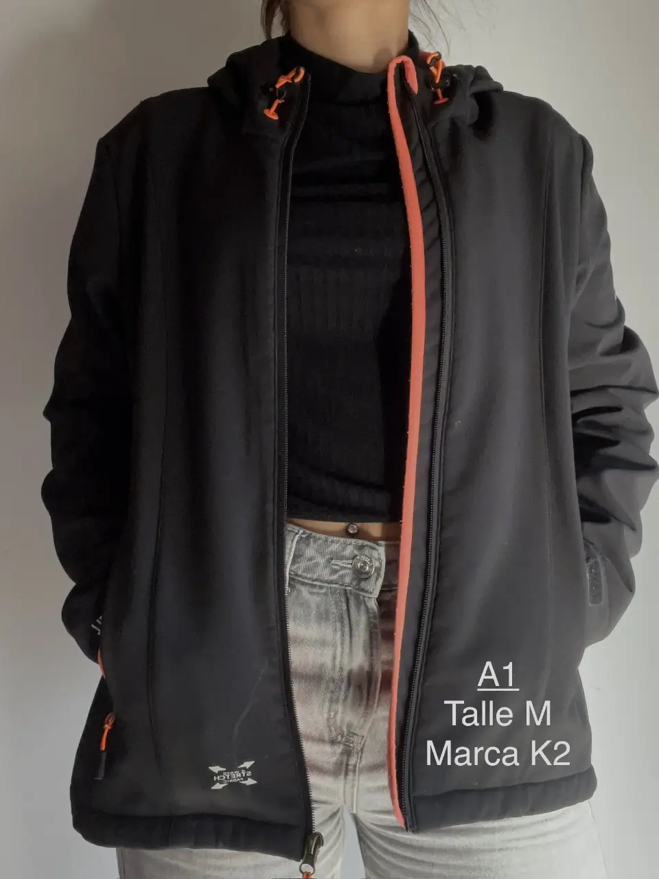 Campera deportiva negra con detalles en naranja, talle M de la marca K2. Ideal para actividades al aire libre.