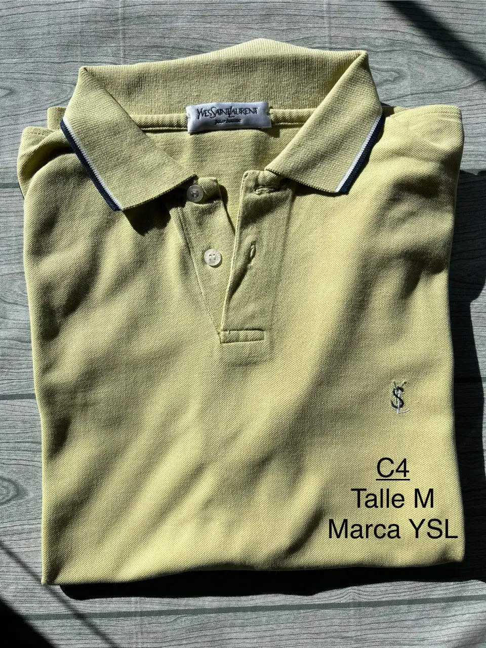 Remera polo de hombre, color amarillo claro, con detalles en blanco y azul en el cuello. Talle M, de la marca YSL.