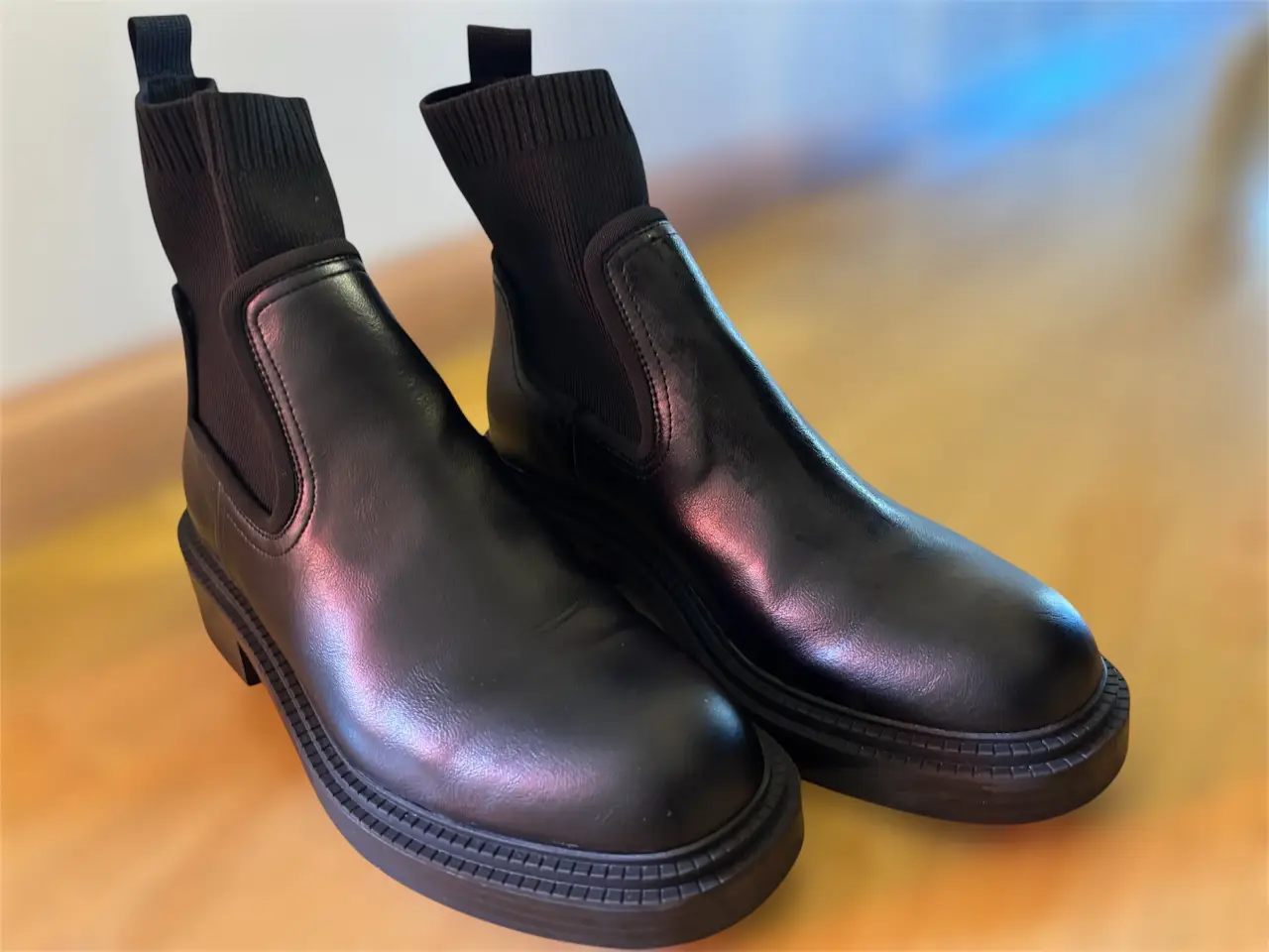 Botines negros de cuero sintético con detalle de tejido en el tobillo. Suela gruesa y diseño moderno. Ideales para un look urbano y cómodo.