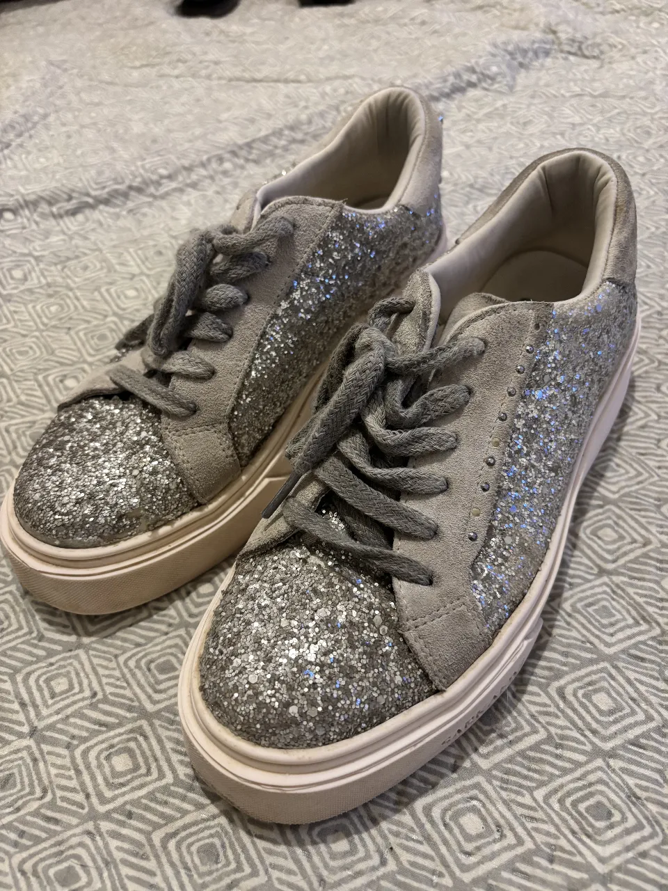 Zapatillas Sofia con glitter plateado y detalles en gamuza gris. Ideales para un look casual y moderno.