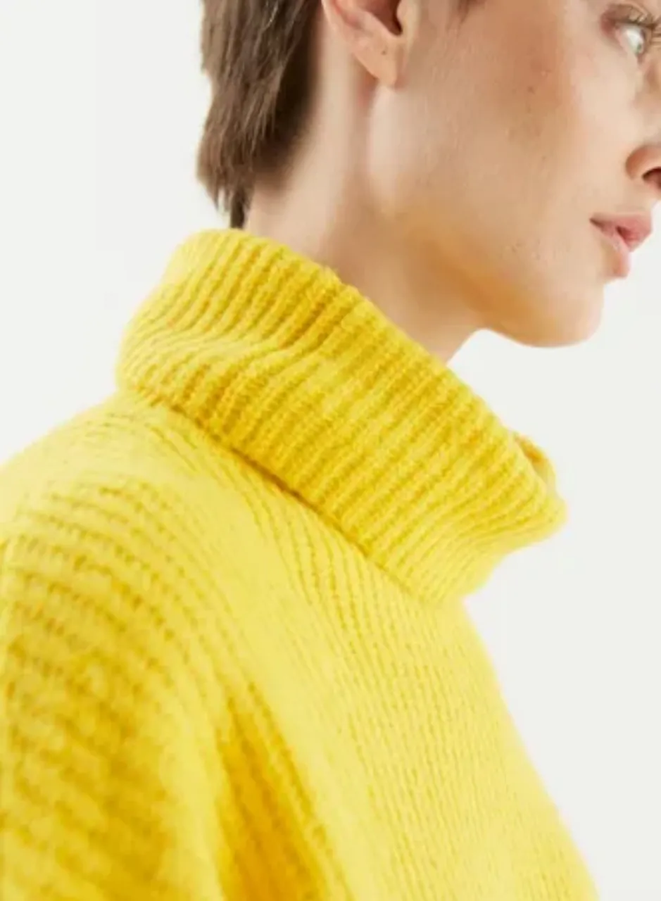 Sweater amarillo de cuello alto, ideal para los días frescos. Su diseño moderno y color vibrante lo convierten en un básico para tu guardarropa.