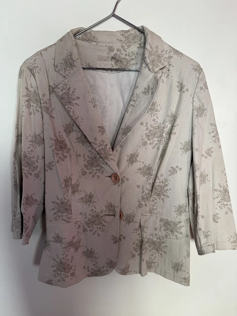 Blazer de mujer con estampado floral en tonos grises. Corte clásico con un botón y mangas 3/4. Ideal para un look elegante y versátil.