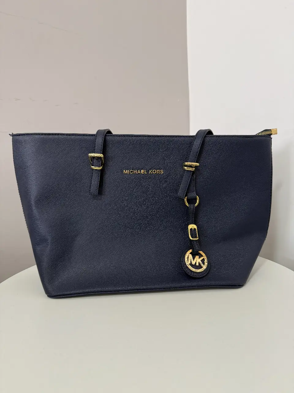 Bolso tote azul marino de Michael Kors, ideal para llevar todo lo necesario con estilo. Confeccionado en material resistente, este bolso es perfecto para el día a día.