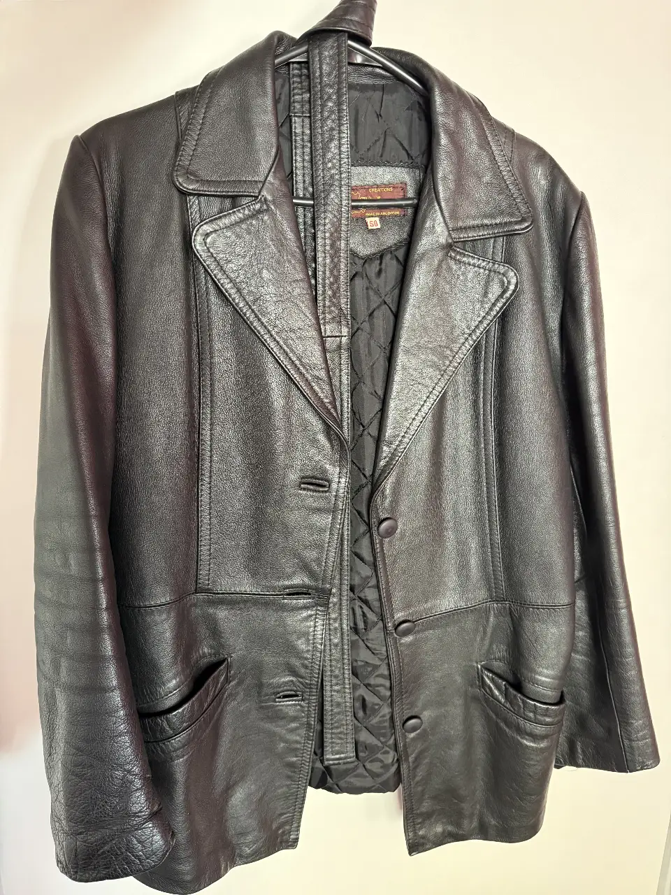 Campera de cuero negra, estilo biker, con botones y bolsillos. Marca MH Italcuero, talle 50. Ideal para un look vintage y elegante.