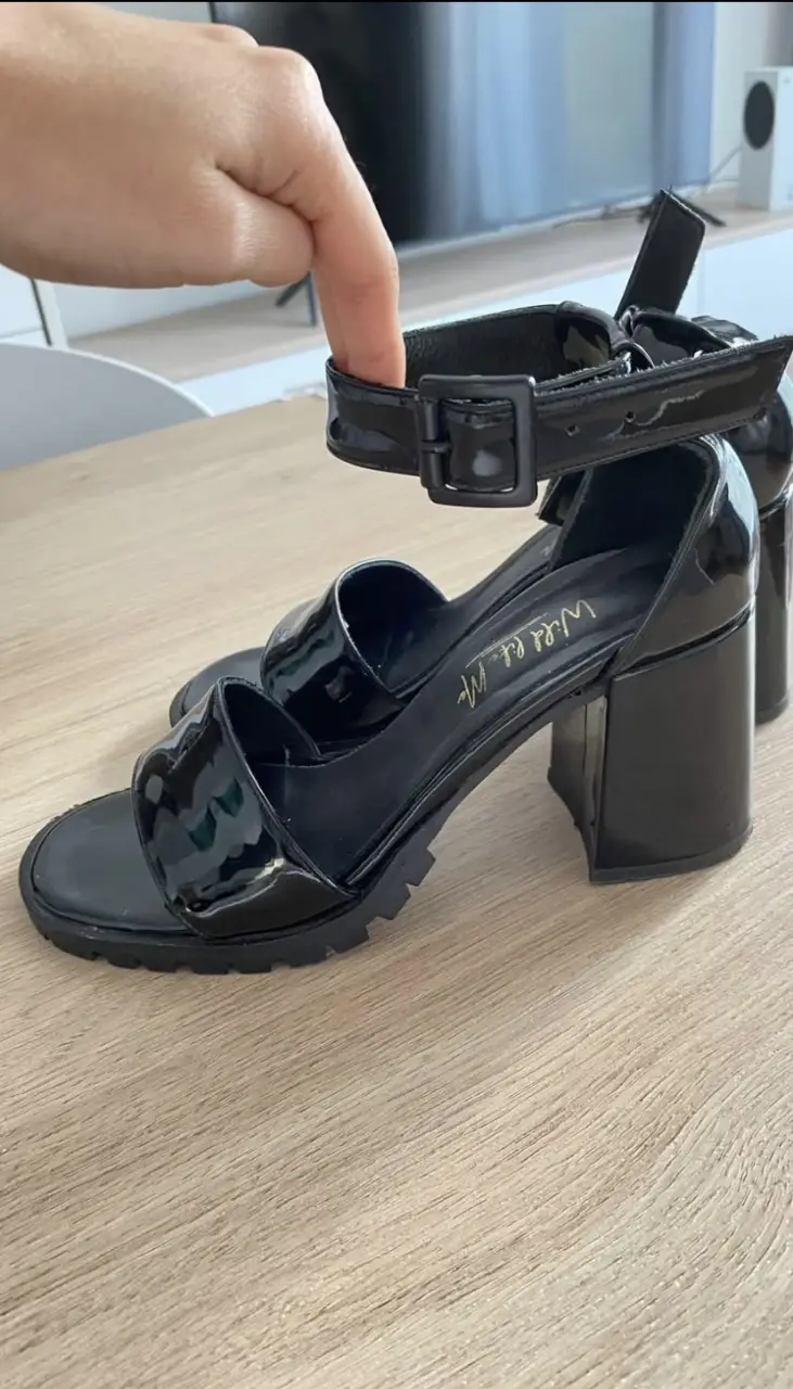 Sandalias de mujer negras de charol con taco ancho y pulsera al tobillo. Ideales para un look elegante y moderno.