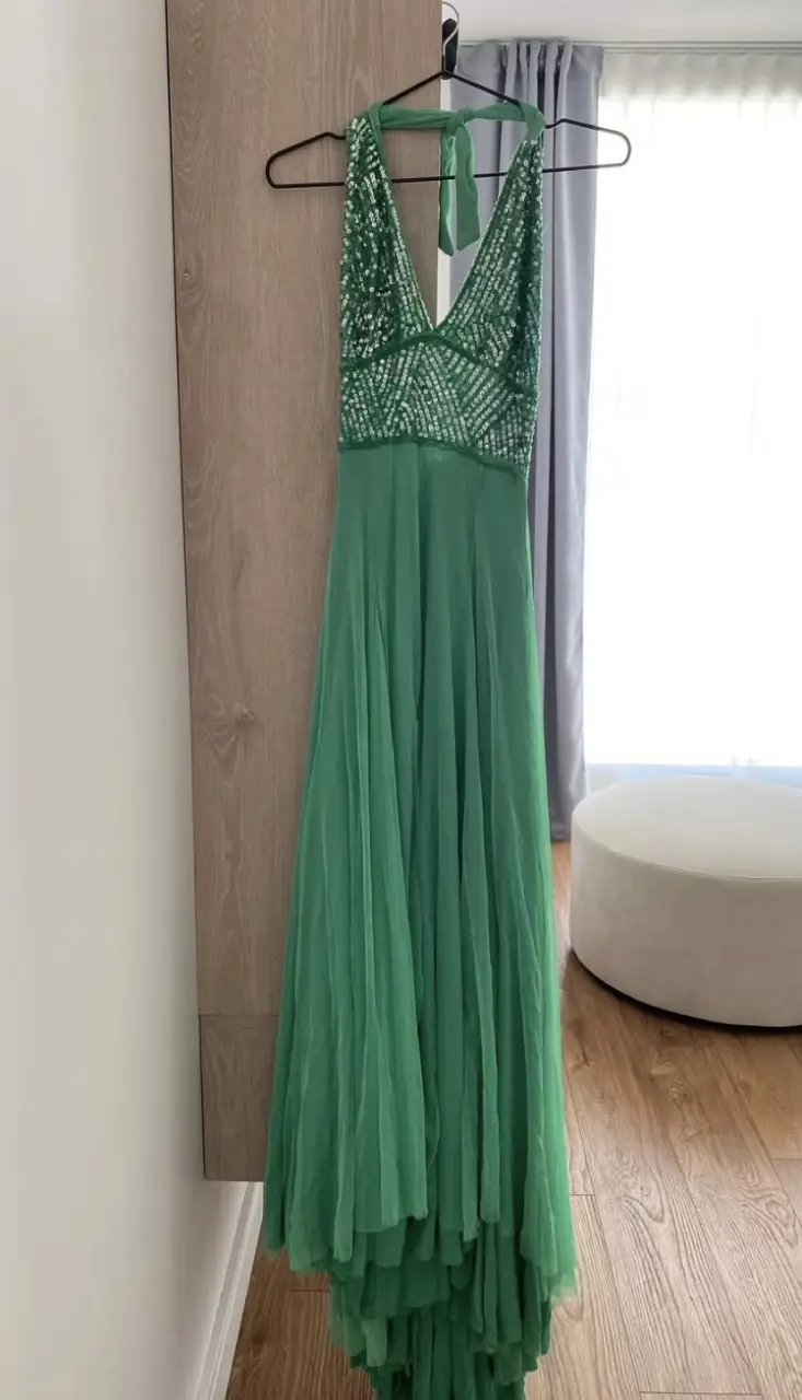 Vestido largo de fiesta, color verde esmeralda. Confeccionado con una parte superior de lentejuelas y falda fluida. Ideal para eventos especiales.