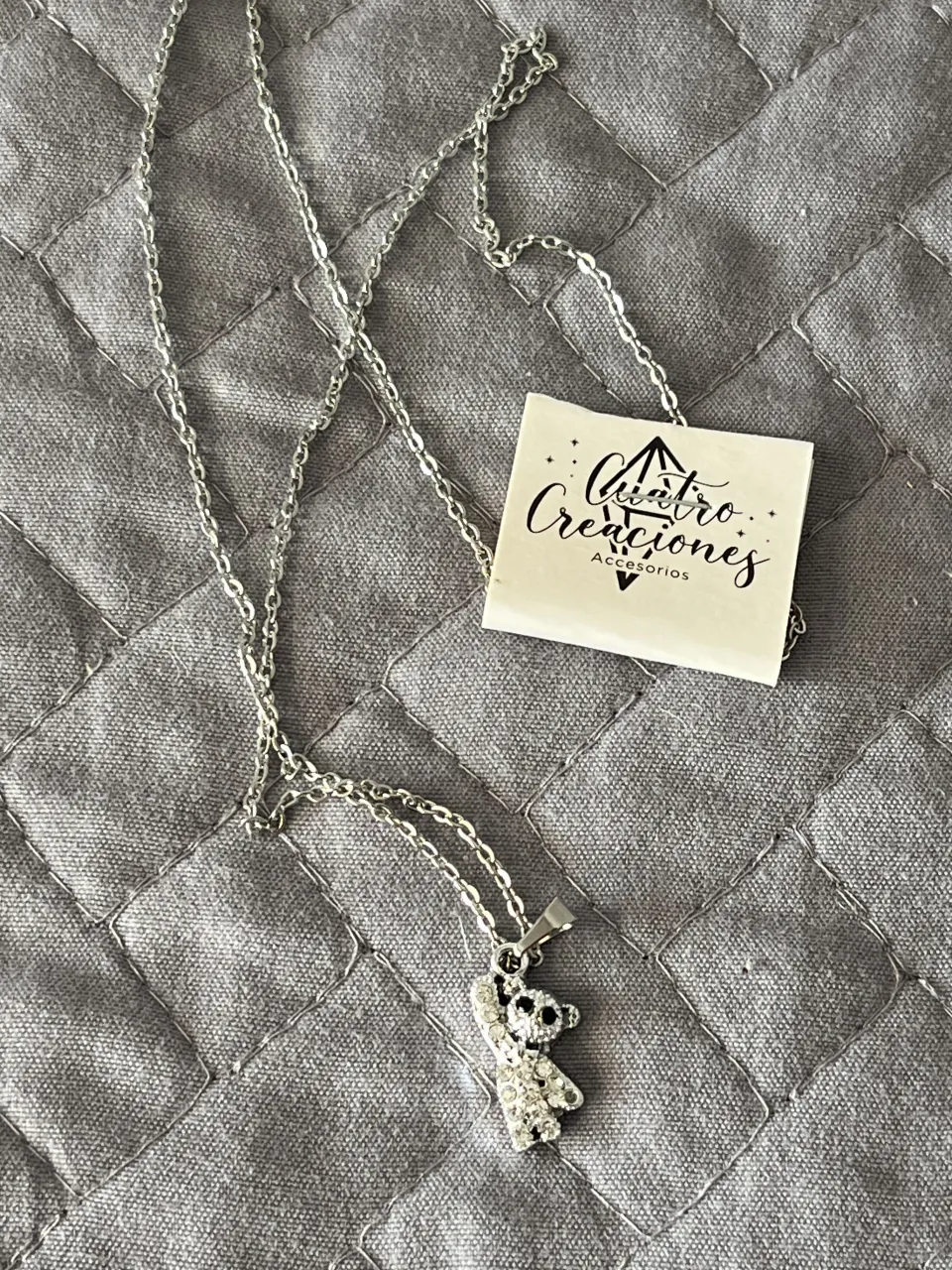 Cadena plateada de acero inoxidable con dije de oso de peluche con strass. 