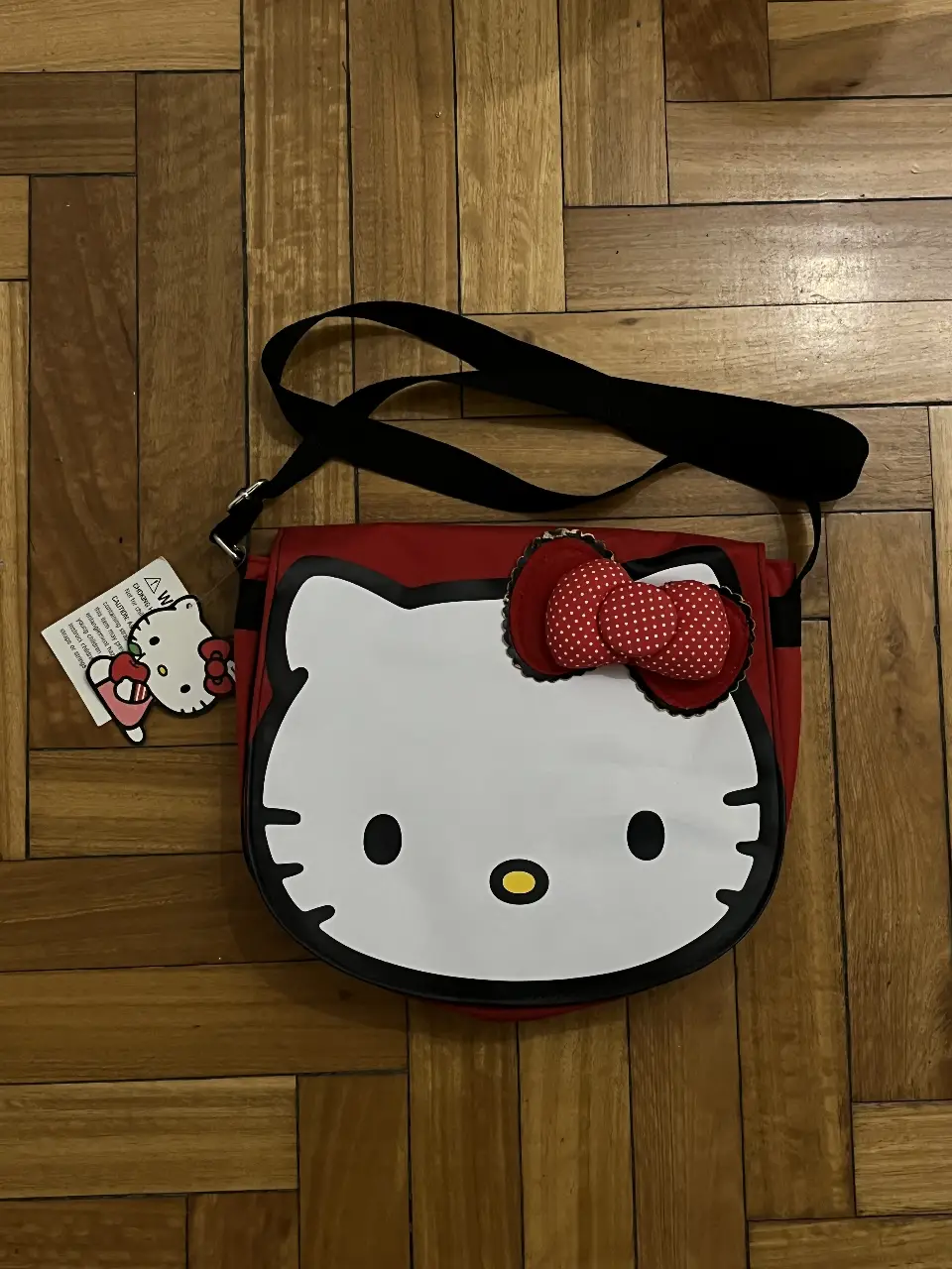 Cartera bandolera de Hello Kitty, con diseño de la cara del personaje. Ideal para llevar tus cosas con estilo y un toque de ternura. Cuenta con 3 bolsillos. 