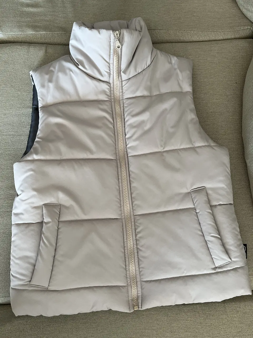 Chaleco acolchado para hombre o mujer, color  claro. Ideal para usar en invierno o entretiempo. Posee cierre y bolsillos.