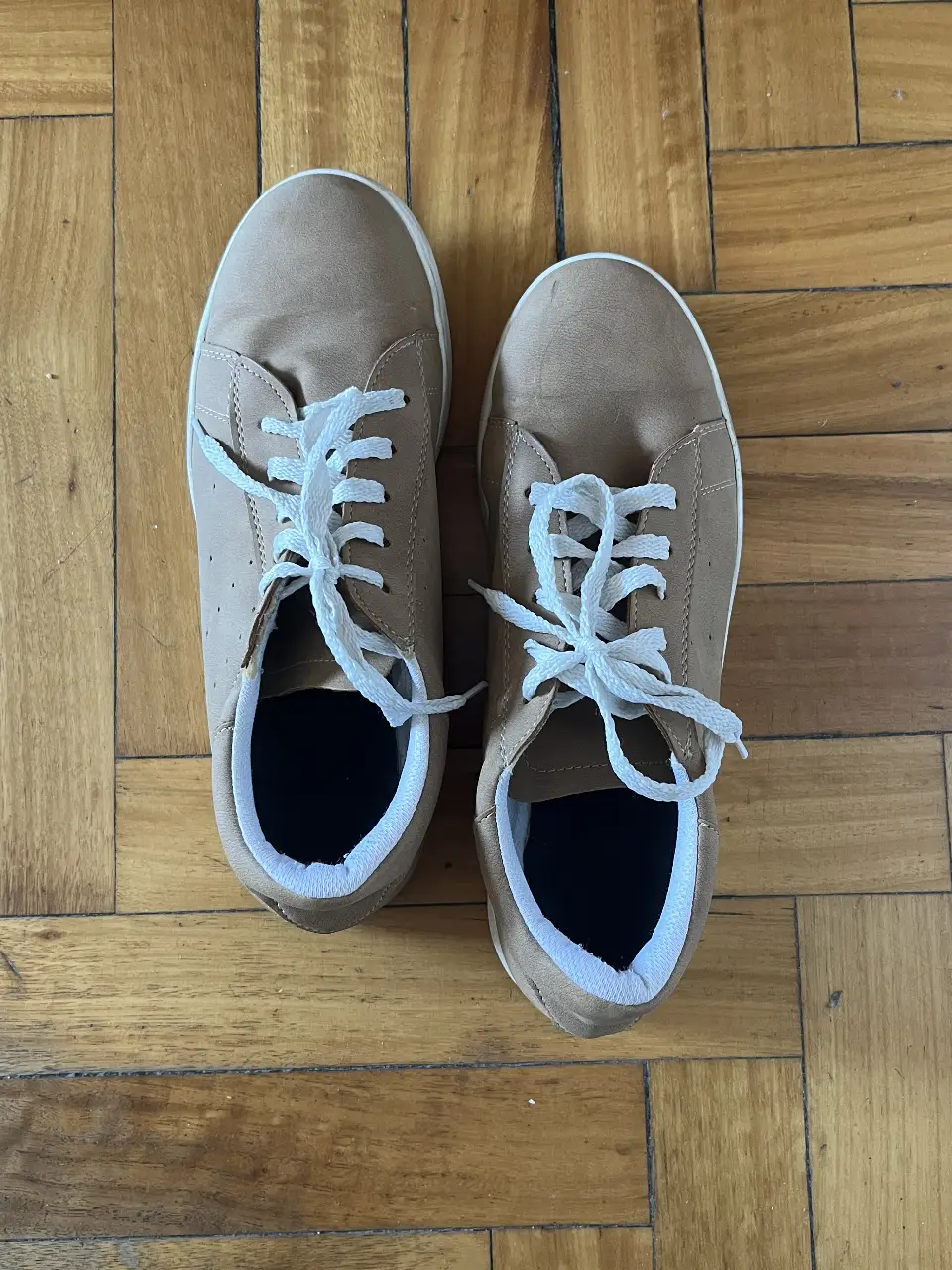 Zapatillas color marrón con cordones blancos. Ideales para un look casual y cómodo.