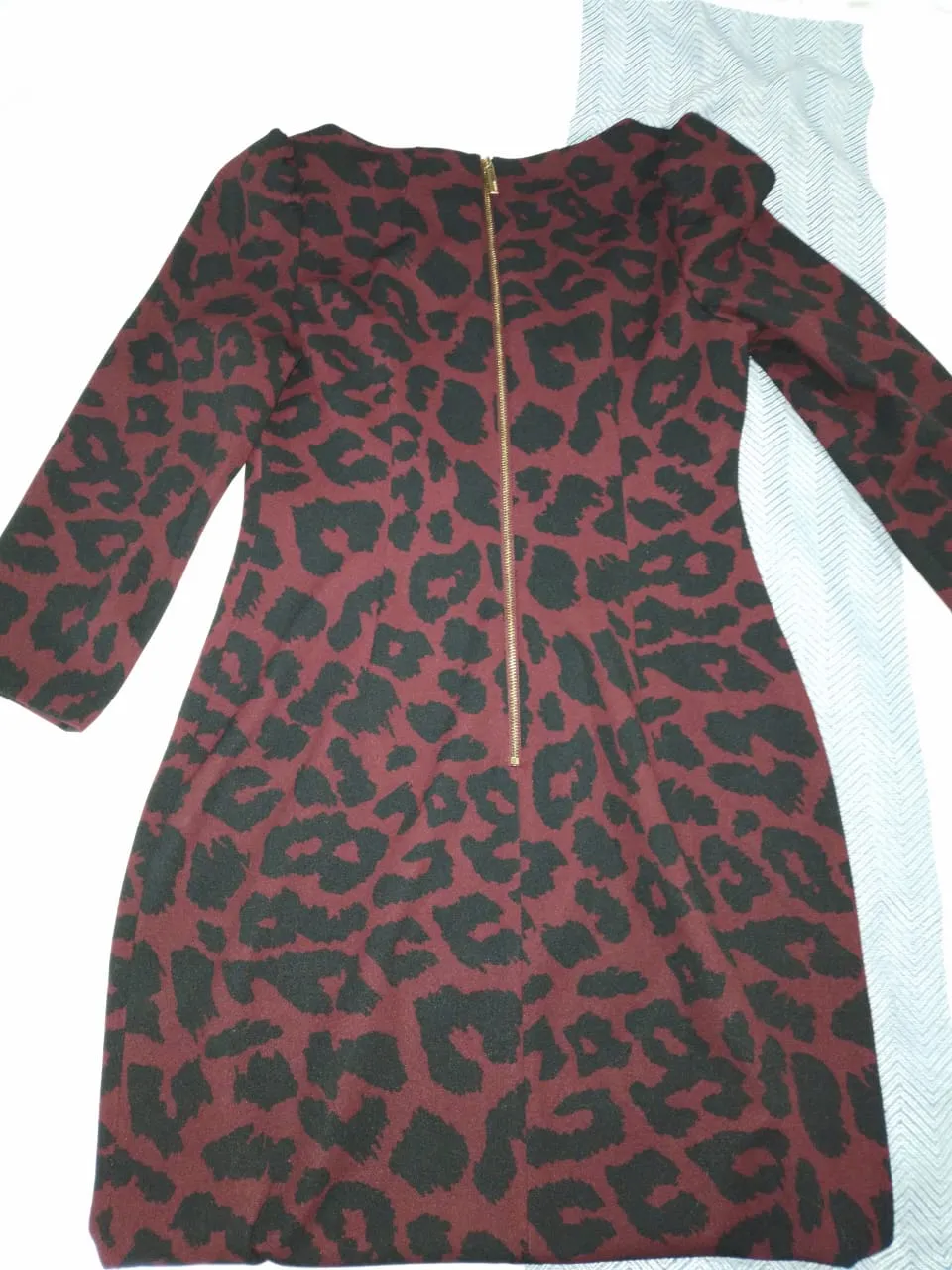 Vestido midi para mujer con estampado de leopardo en tonos borgoña y negro. Diseño elegante con mangas largas y cierre en la espalda. Ideal para eventos especiales o salidas nocturnas.