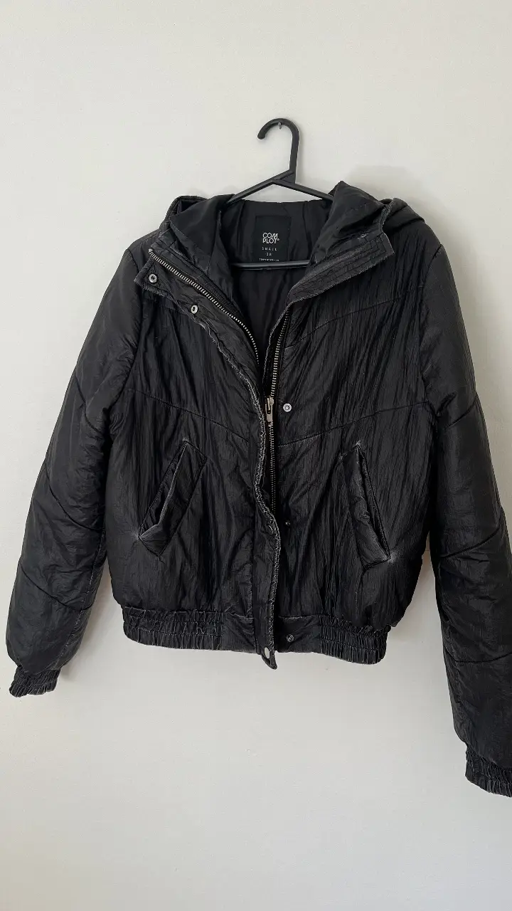Campera bomber negra con capucha, cierre y bolsillos. Ideal para un look casual y abrigado. La tela es tipo para lluvia, tiene un  buen estado general. Talle S en la etiqueta pero va para M también 