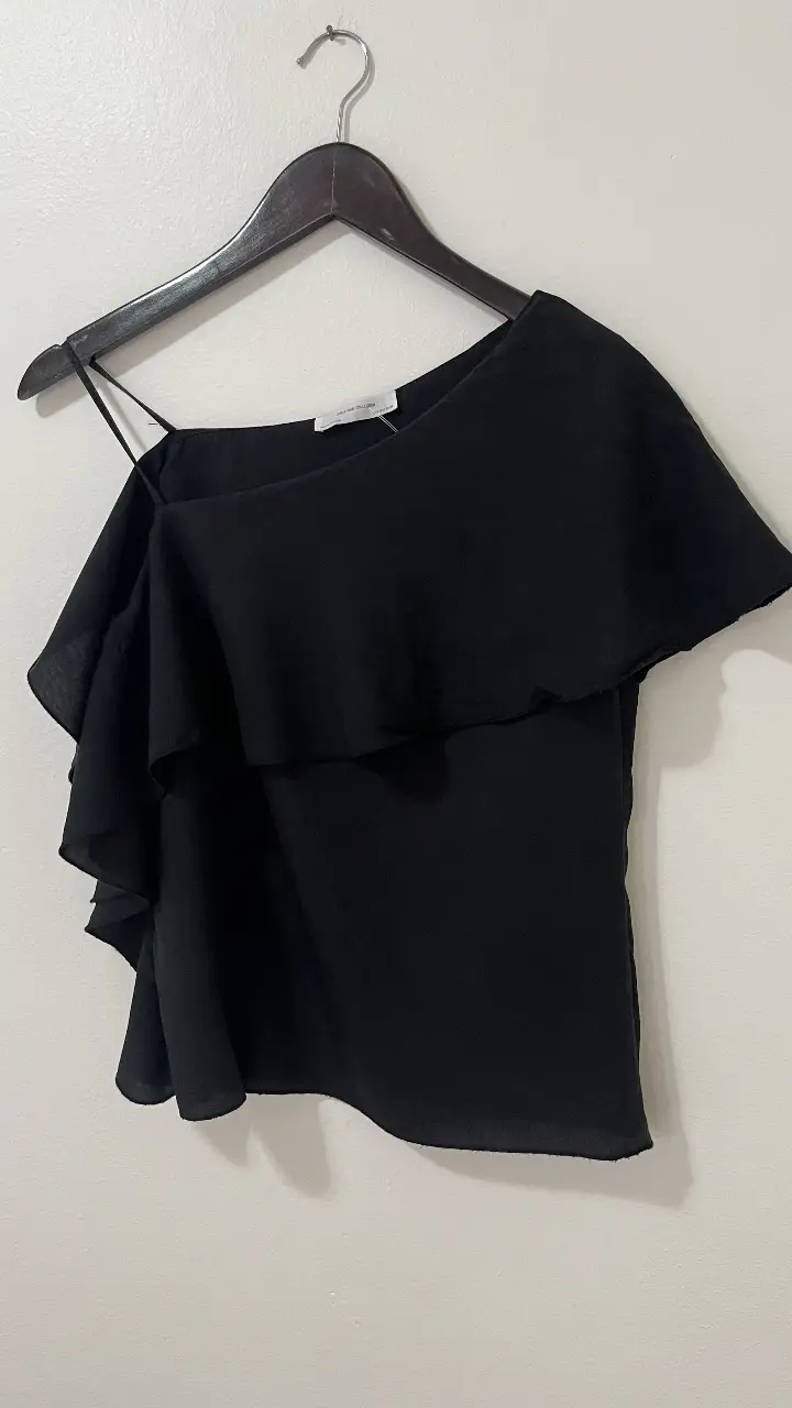 Top negro asimétrico con volados, ideal para una salida o evento especial. De la marca Zara W&B Collection, hecho en Portugal.