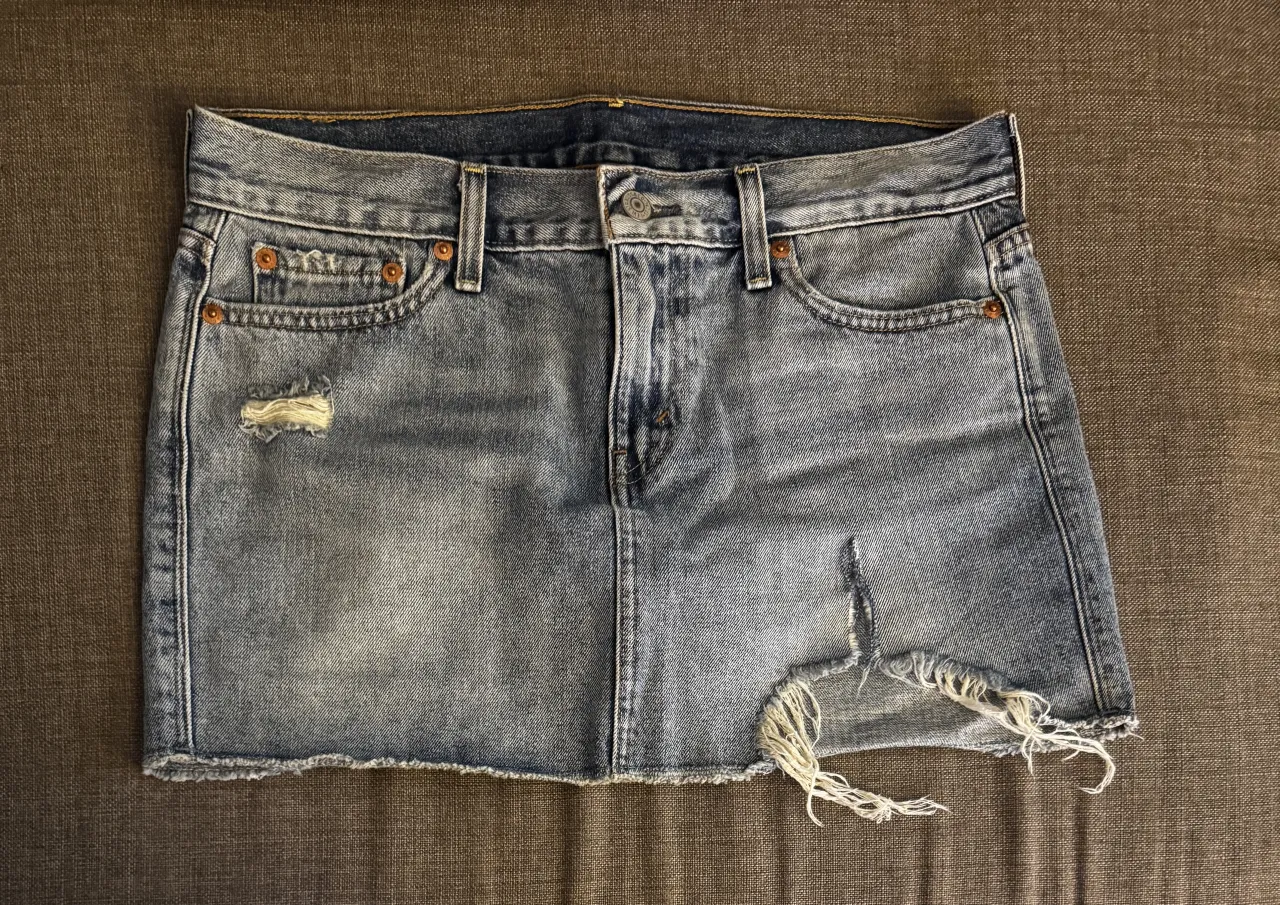 Pollera de jean tiro alto, con roturas y desgastes que le dan un toque moderno y canchero. Perfecta para un look casual y descontracturado.