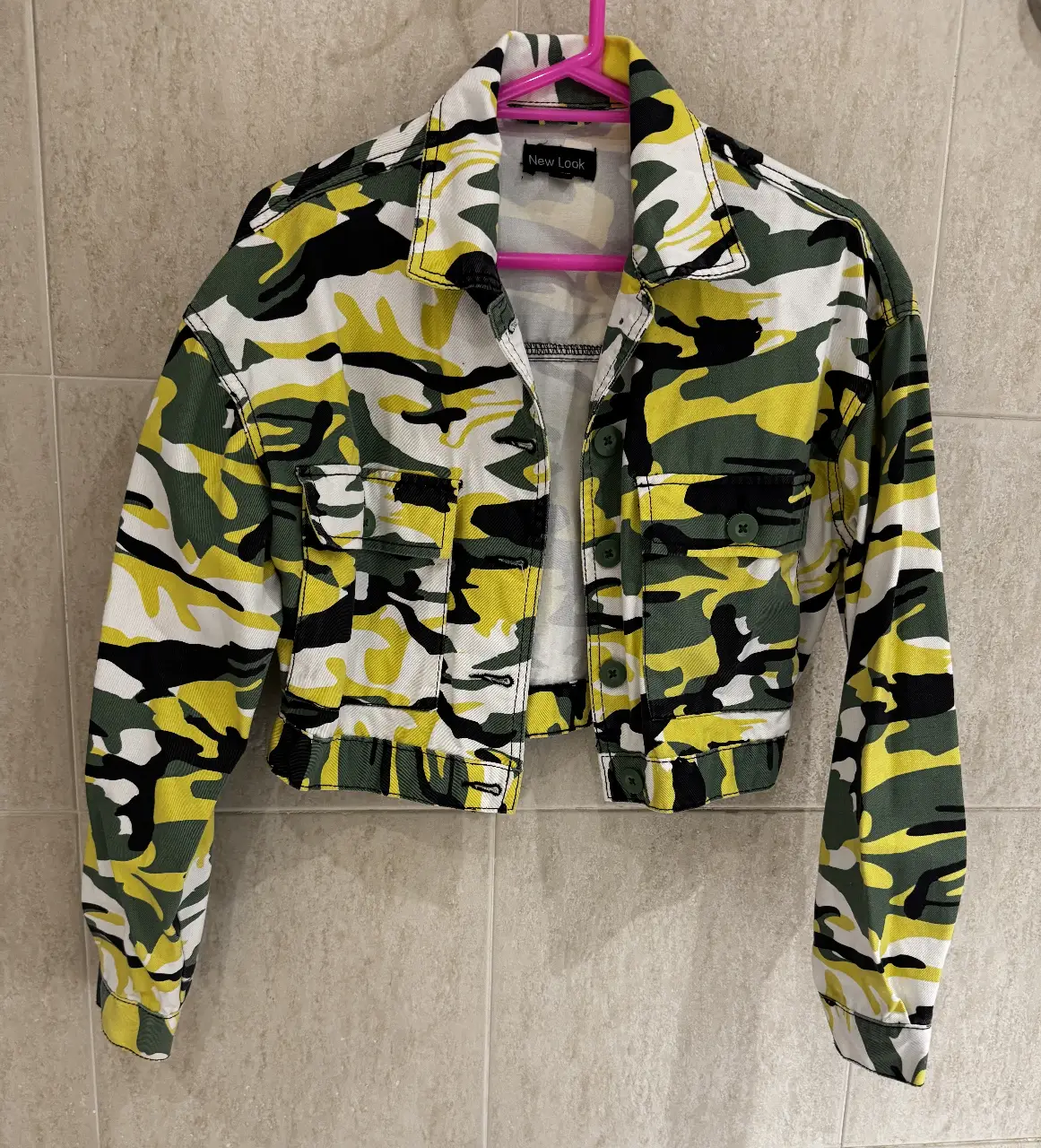 Campera de jean New Look con estampado camuflado en tonos verde, amarillo, blanco y negro. Corte cropped, ideal para un look moderno y canchero. Talle S.