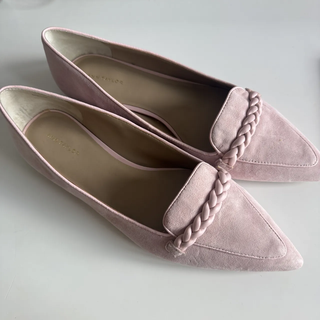 Zapatos planos color rosa pálido, con punta fina y detalle de trenza en la capellada. 