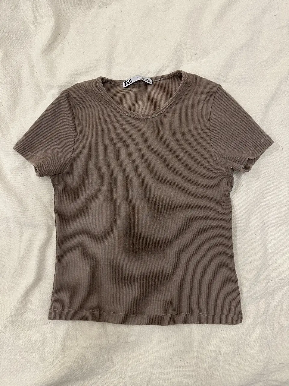 Remera manga corta de tejido acanalado en color marrón. Ideal para un look casual y cómodo. Talle S, de la marca Zara.