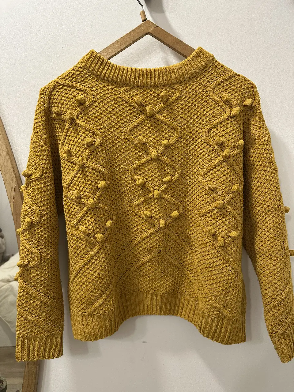 Sweater tejido de color mostaza con detalles en relieve y diseño en rombos. Ideal para un look casual y abrigado.
