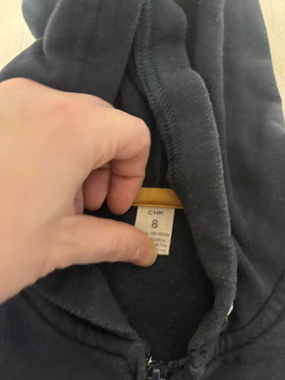 Buzo con cierre para niño, color azul marino con detalles en amarillo. Estampado "Ride On" en el frente. Talle 8.