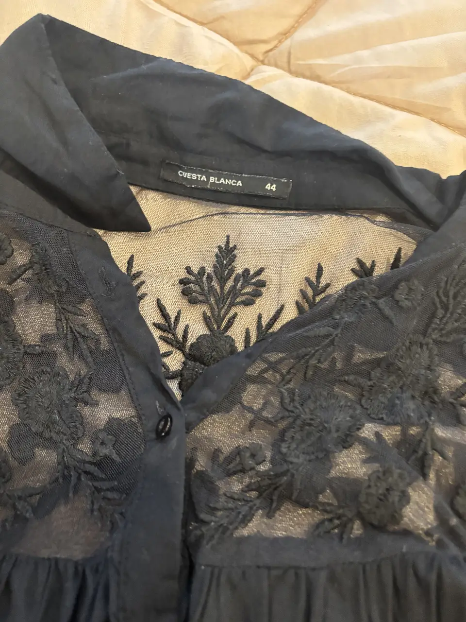 Blusa negra con detalles de encaje en el frente y mangas largas. Ideal para un look elegante y sofisticado.