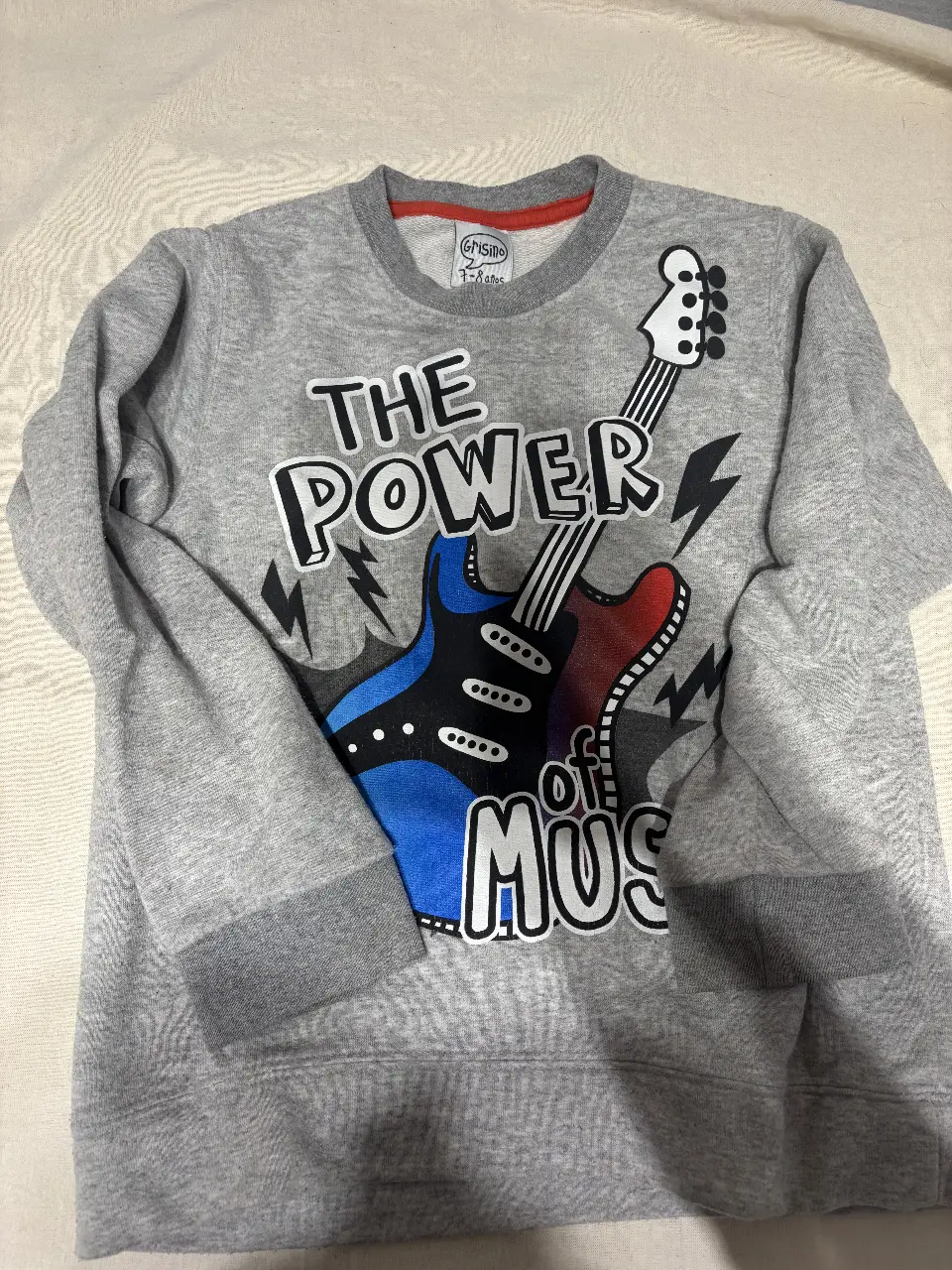 Buzo de cuello redondo para niño, de color gris con estampado de guitarra eléctrica en tonos azul y rojo con la frase 'The Power of Music'. Ideal para un look casual y moderno.