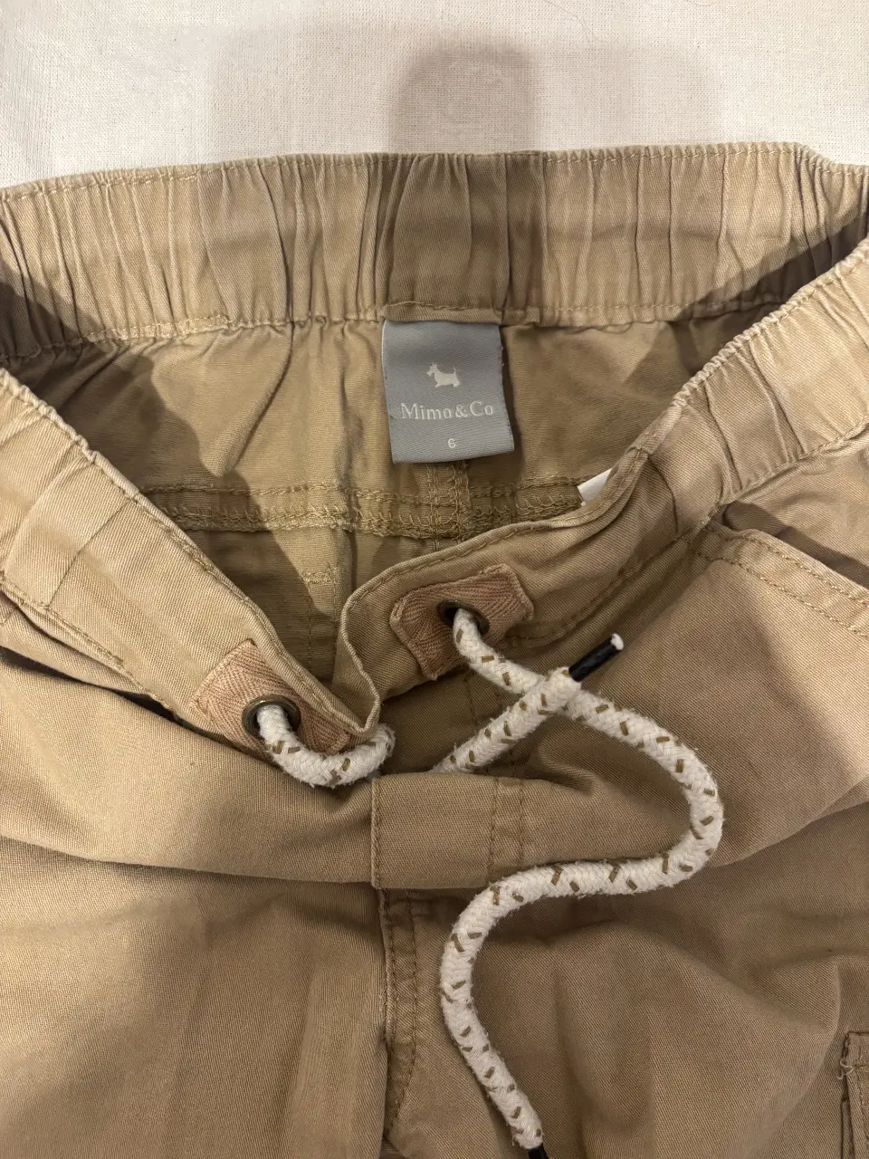 Pantalón cargo color khaki para niño, con bolsillos laterales y ajuste con cordón. Talle 6.