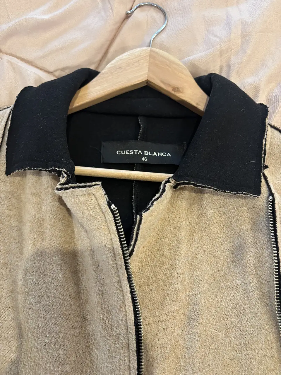 Campera de mujer en color crudo con detalles en negro. Cuello y puños negros. Cierre frontal. Marca Cuesta Blanca. Talle 46.