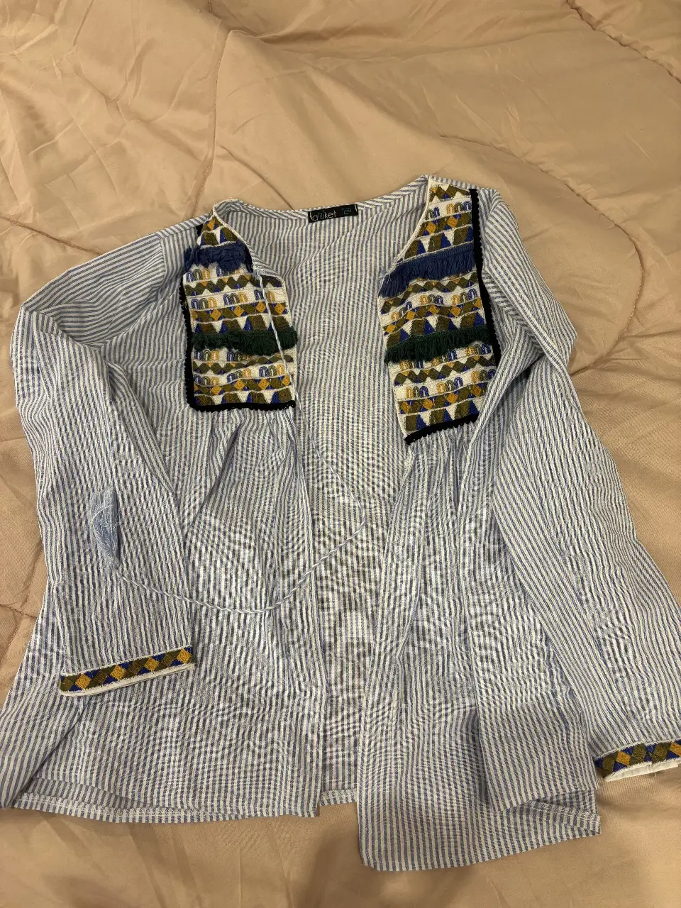 Camisa a rayas azul y blanca con detalles bordados en los hombros y puños. Estilo boho chic, ideal para un look casual y con onda.