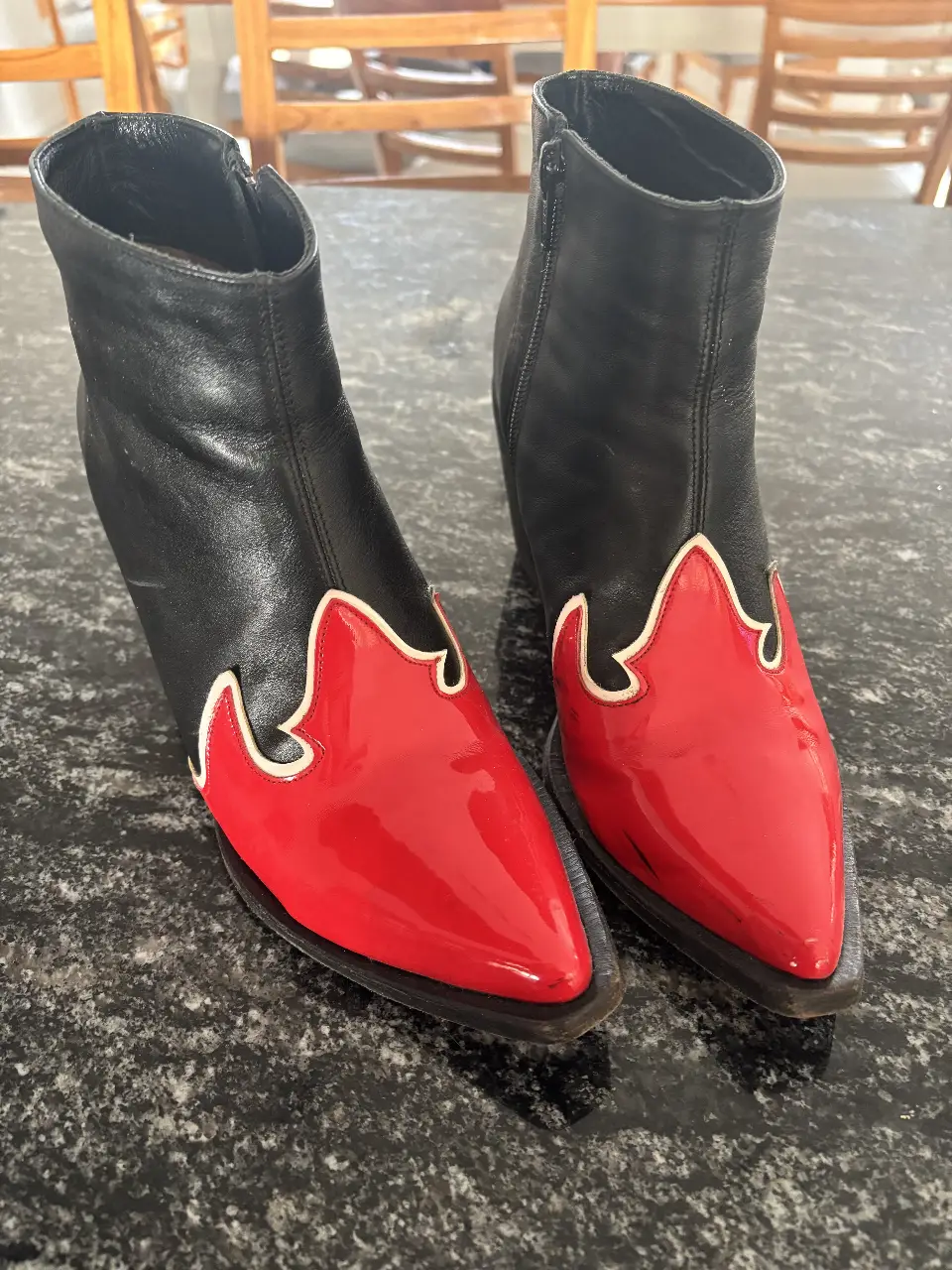 Botines de cuero negro con detalles en rojo charol y borde blanco. Estilo cowboy, ideales para darle un toque audaz a cualquier look.
