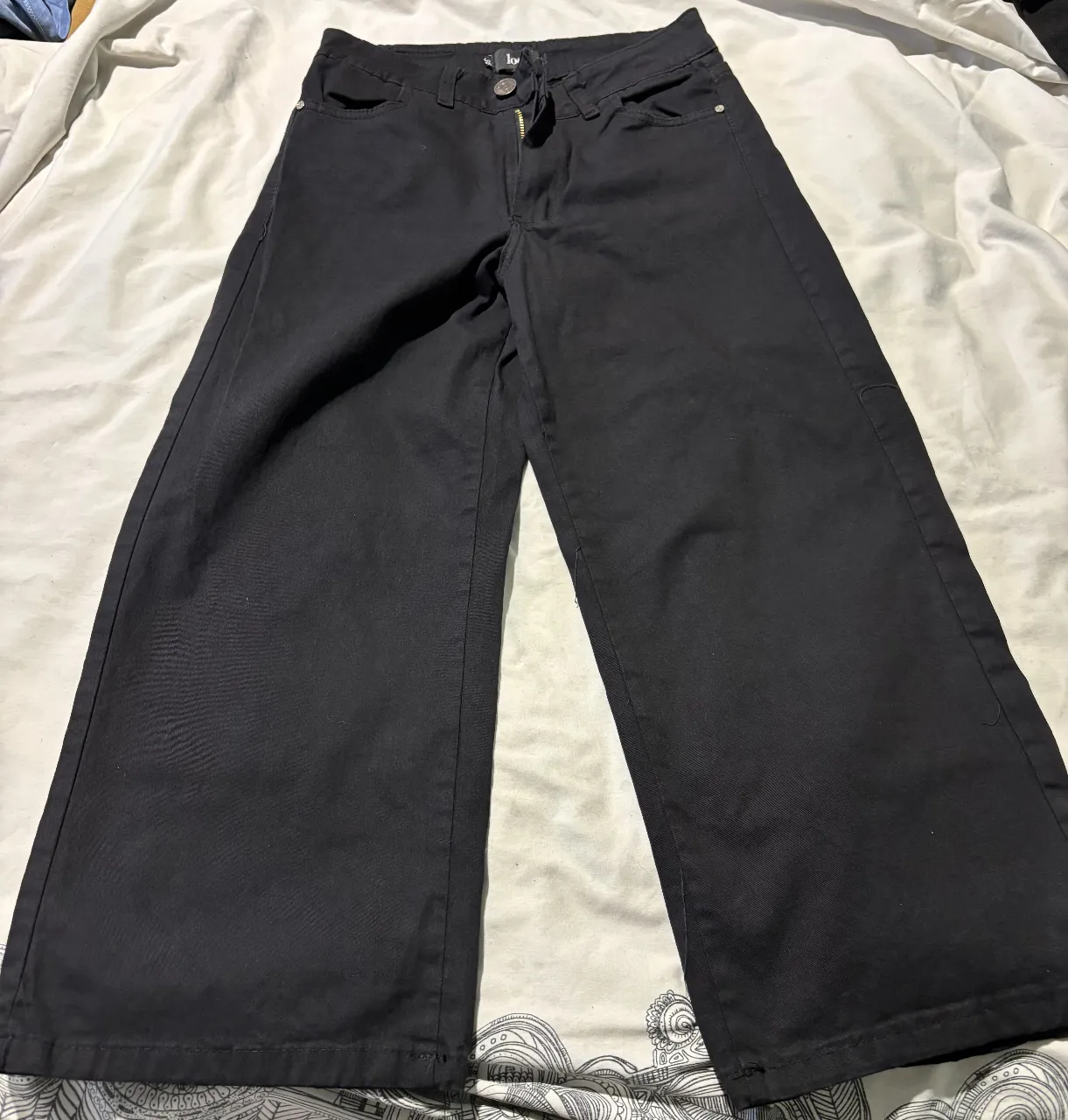 Pantalón negro de mujer, estilo palazzo, tiro medio. Confeccionado en tela resistente, ideal para un look casual y moderno. Talle 38.