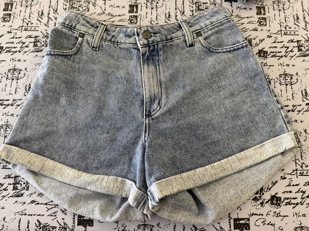 Shorts de jean tiro alto con roturas y dobladillo en la parte inferior. Posee bolsillos delanteros y traseros.