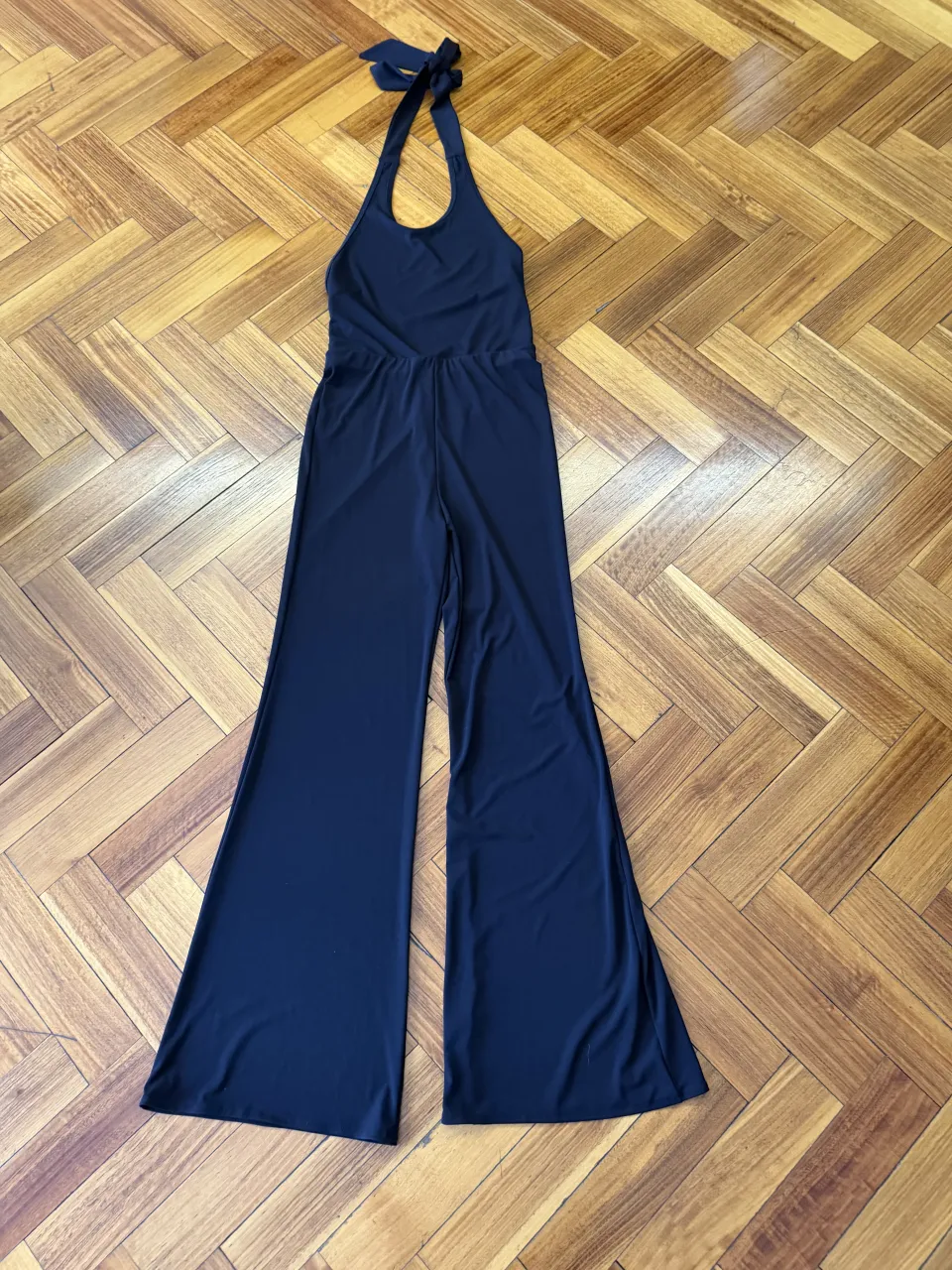 Mono largo de color negro con cuello halter y lazo en la nuca. Piernas anchas y acampanadas.