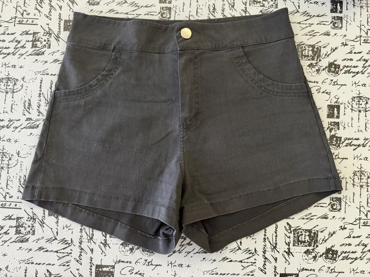Shorts de jean color negro. Posee dos bolsillos delanteros y dos bolsillos traseros. Cierre con un botón en la parte delantera. Elastizado.