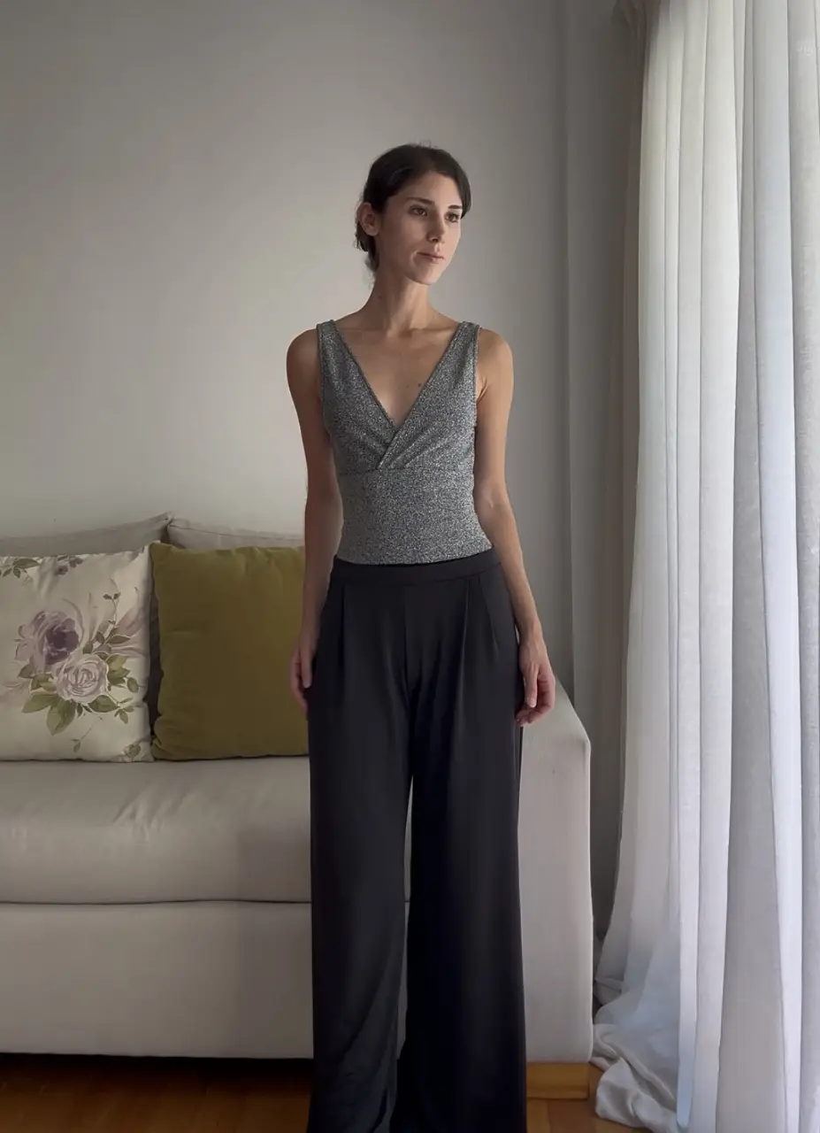 Body con escote en V y diseño brillante. Ideal para combinar con pantalones de vestir para un look elegante. Muy buen estado. 