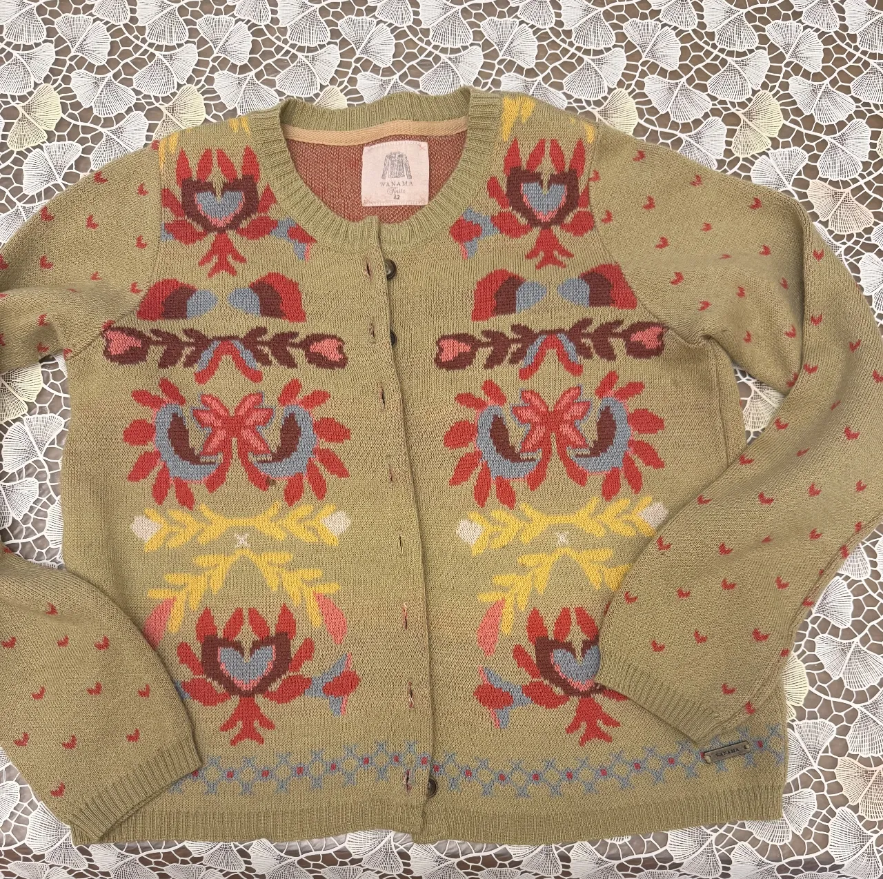 Cardigan de lana con diseño floral en tonos amarillos, rojos y azules. Ideal para un look vintage y abrigado.