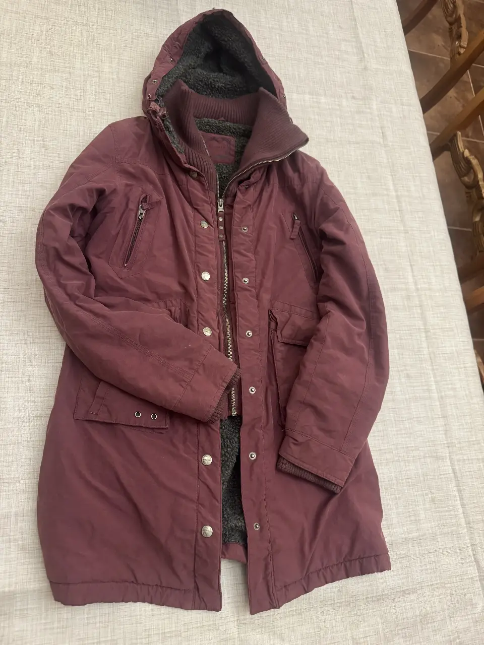 Campera larga de abrigo para mujer, color borgoña. Con capucha con borde de piel sintética, cierre y bolsillos. Ideal para el invierno.