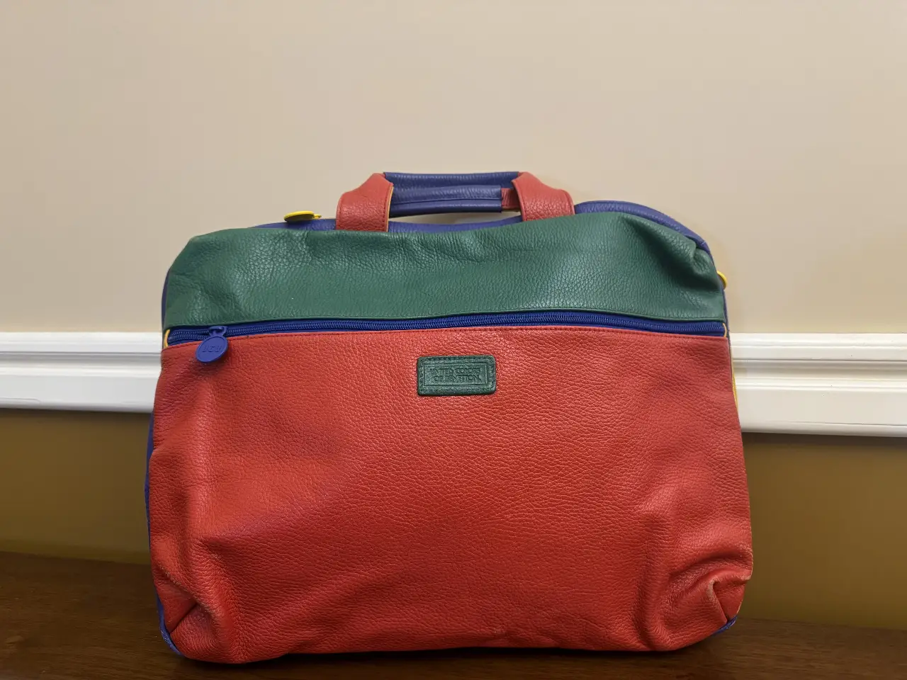 Bolso de mano multicolor con diseño retro. Combina rojo, verde, azul y detalles en amarillo. Ideal para un look vintage y llamativo.