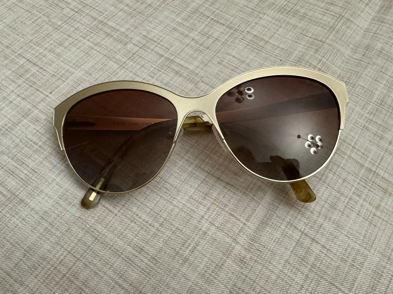 Anteojos de sol Sophia Loren C665-C2, con marco dorado y lentes marrones. Estilo retro/vintage, ideales para un look elegante y casual.