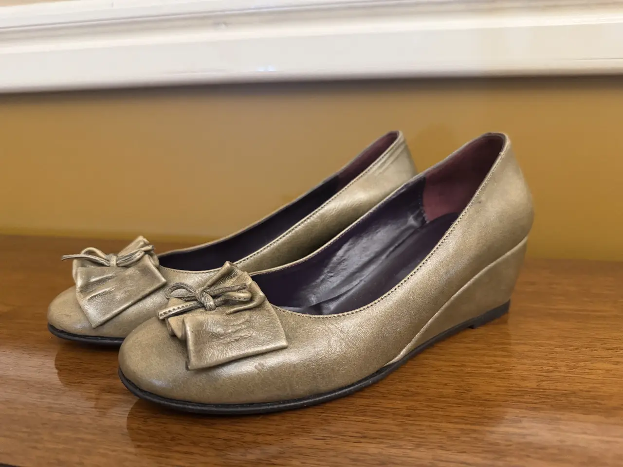 Ballerinas doradas con detalle de moño. Ideales para un look elegante y cómodo.