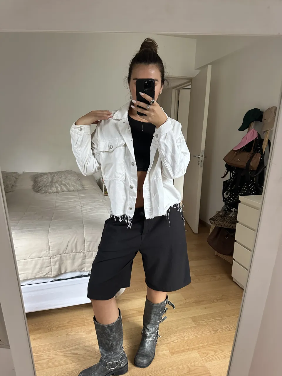 Campera blanca tipo camisa de jean con botones al frente, bolsillos en el pecho y detalles deshilachados en puños y ruedo.