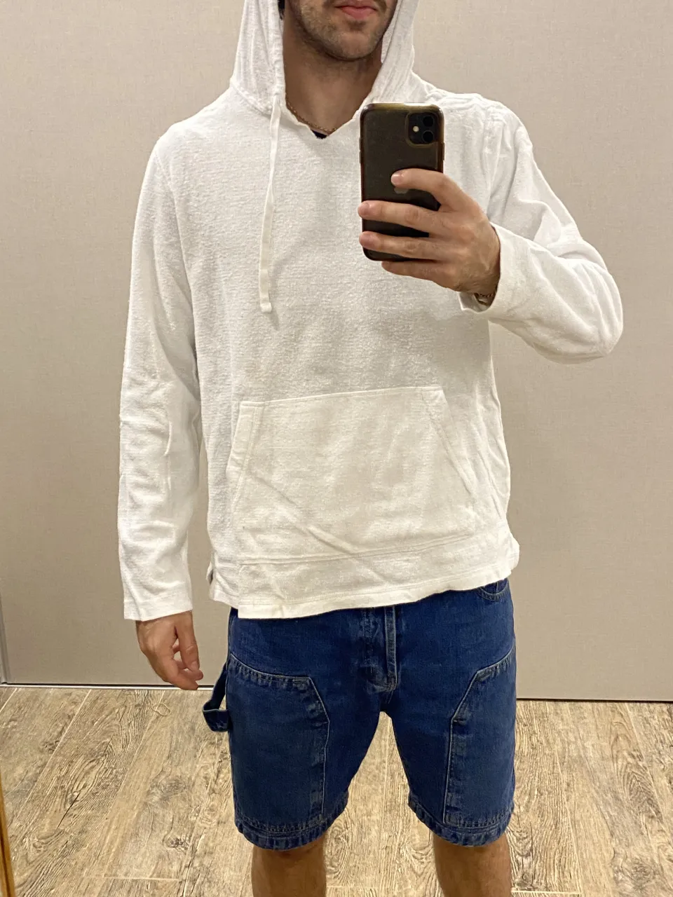 Buzo blanco con capucha y cordones. Posee bolsillo canguro delantero.